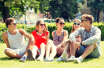 Image showing group of smiling friends outdoors sitting on grass