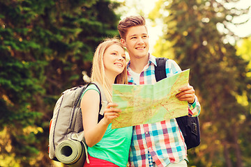 Image showing smiling couple with map and backpack in forest