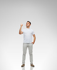 Image showing smiling man pointing finger up