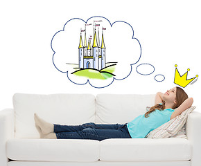 Image showing smiling little girl lying on sofa and dreaming