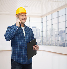 Image showing smiling male builder in helmet with clipboard