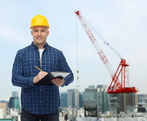 Image showing smiling male builder in helmet with clipboard