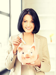 Image showing lovely woman with piggy bank and money