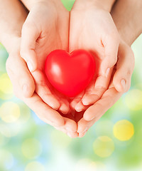 Image showing close up of couple hands holding red heart