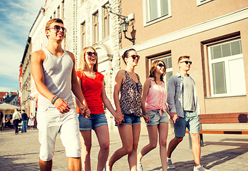 Image showing group of smiling friends walking in city