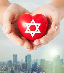 Image showing close up of hands holding heart with jewish star