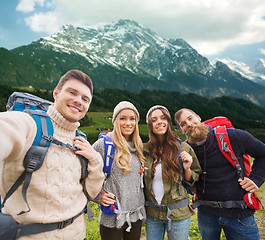 Image showing group of smiling friends with backpacks hiking