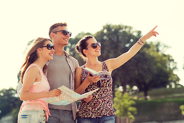 Image showing smiling friends with map and city guide outdoors