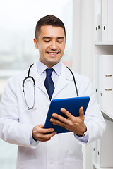 Image showing smiling male doctor in white coat with tablet pc