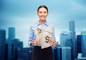 Image showing businesswoman holding money bags with euro