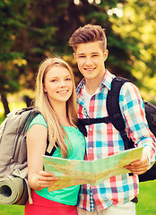 Image showing smiling couple with map and backpack in forest