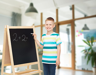 Image showing happy little boy with blackboard and chalk