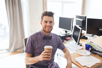 Image showing happy creative male office worker drinking coffee