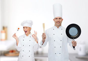 Image showing happy male chef holding frying pan and spatula