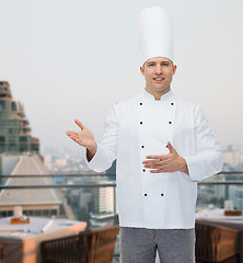 Image showing happy male chef cook inviting