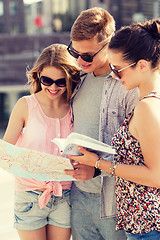 Image showing smiling friends with map and city guide outdoors