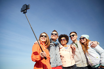 Image showing smiling friends taking selfie with smartphone