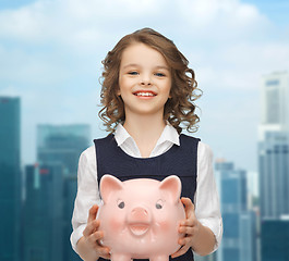 Image showing happy girl holding piggy bank 