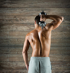 Image showing young man with dumbbell flexing biceps