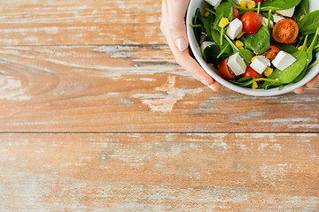 Image showing close up of young woman hands with salad bowl