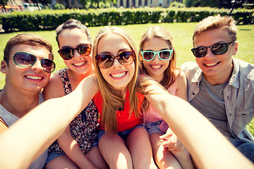 Image showing group of smiling friends making selfie in park