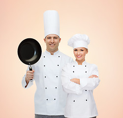 Image showing happy chefs or cooks couple with frying pan