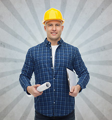 Image showing smiling male builder in helmet with blueprint