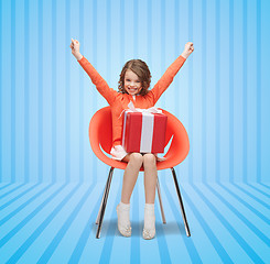 Image showing happy little girl with gift boxes sitting on chair