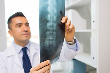 Image showing close up of doctor in white coat looking at x-ray