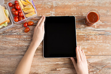 Image showing close up of woman with tablet pc food on table