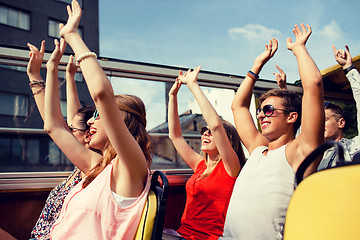 Image showing group of smiling friends traveling by tour bus