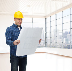 Image showing smiling male builder in helmet with blueprint