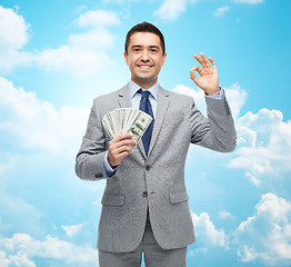 Image showing smiling businessman with american dollar money