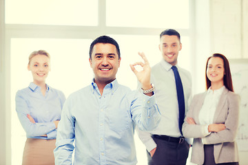 Image showing smiling businessman showing ok-sign in office