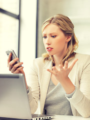 Image showing confused woman with cell phone