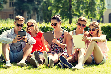 Image showing smiling friends with tablet pc computers in park