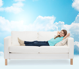 Image showing smiling little girl lying on sofa
