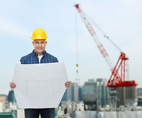 Image showing smiling male builder in helmet with blueprint