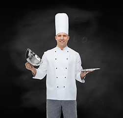 Image showing happy male chef cook opening cloche