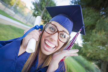 Image showing Expressive Young Woman Holding Diploma in Cap and Gown