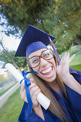 Image showing Expressive Young Woman Holding Diploma in Cap and Gown