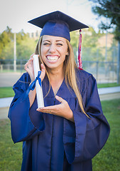 Image showing Expressive Young Woman Holding Diploma in Cap and Gown