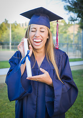 Image showing Expressive Young Woman Holding Diploma in Cap and Gown
