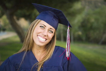 Image showing Young Woman Wearing Cap and Gown Outdoors