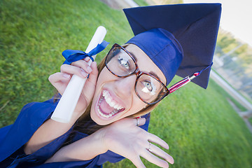 Image showing Expressive Young Woman Holding Diploma in Cap and Gown