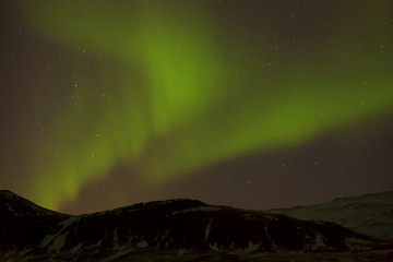 Image showing Northern lights with snowy mountains in the foreground