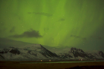 Image showing Northern lights with snowy mountains in the foreground