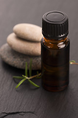 Image showing Essential oil with rosemary and fresh green leaves 