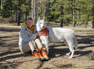 Image showing Woman with a white dog in a wood