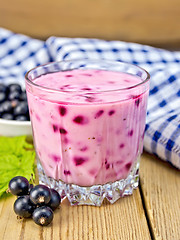 Image showing Milkshake with black currants in glass on board